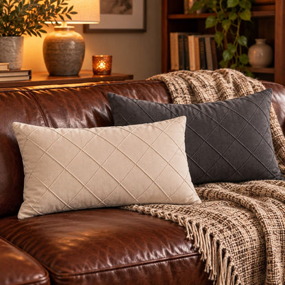 Housses coussin blanc crème et gris anthracite matelassées sur canapé en cuir