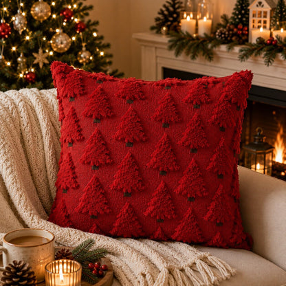 Housse de coussin de Noël rouge avec sapins en relief sur un canapé chaleureux