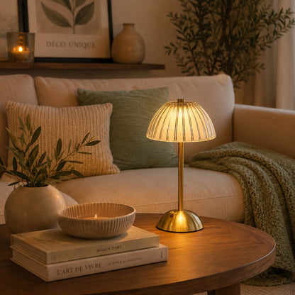 Lampe de table rechargeable Éclat Précieux modèle dôme, posée sur une table basse dans un salon chaleureux aux tons beige et vert sauge