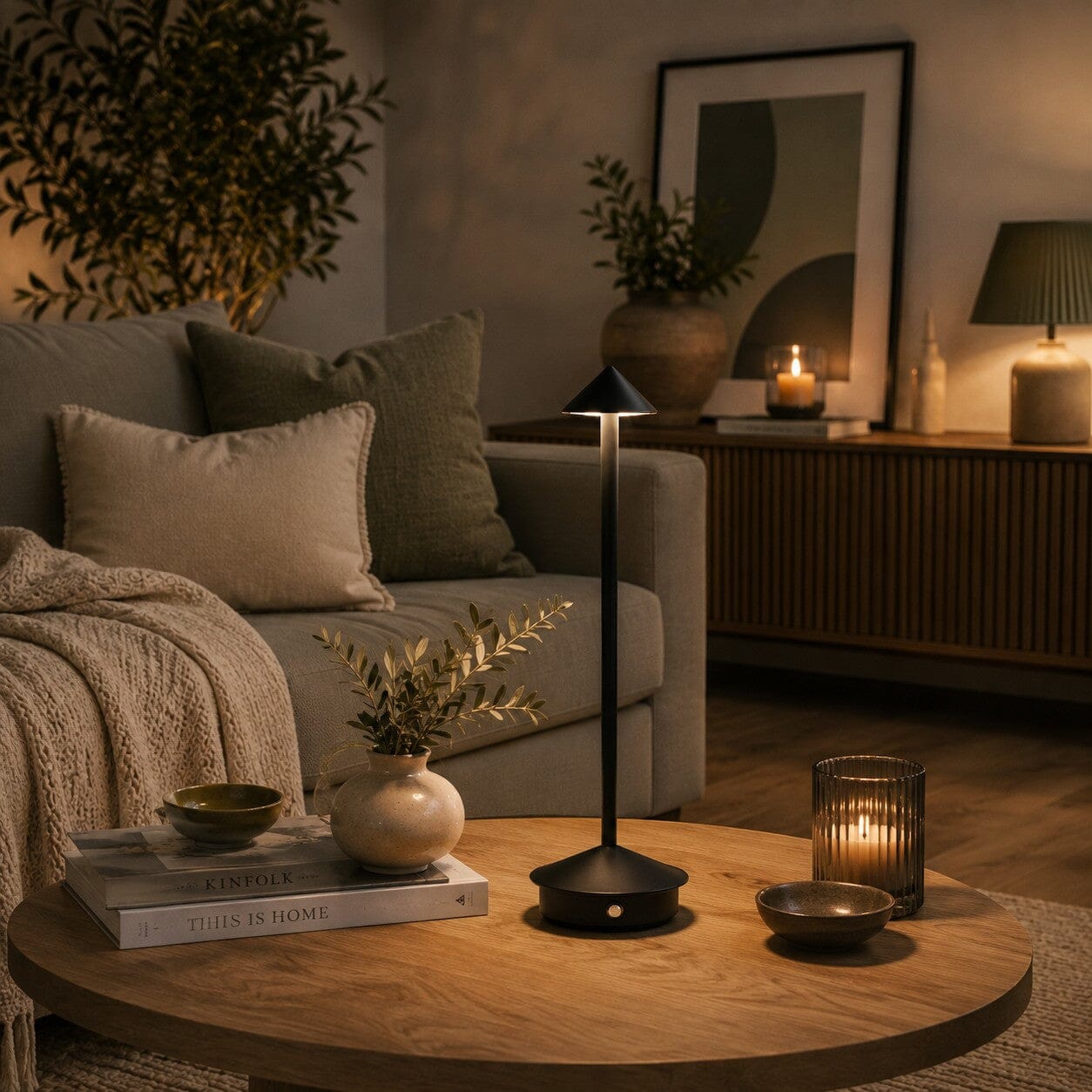 Lampe de table sans fil Éclat Nomade noire dans un salon chaleureux aux tons naturels et vert sauge